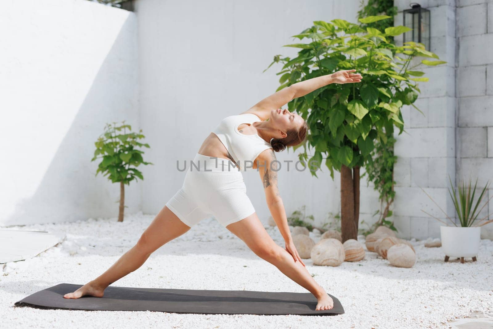 yoga stretching outdoors. side view of overweight woman practicing yoga on white background, body care concept, outdoor workout