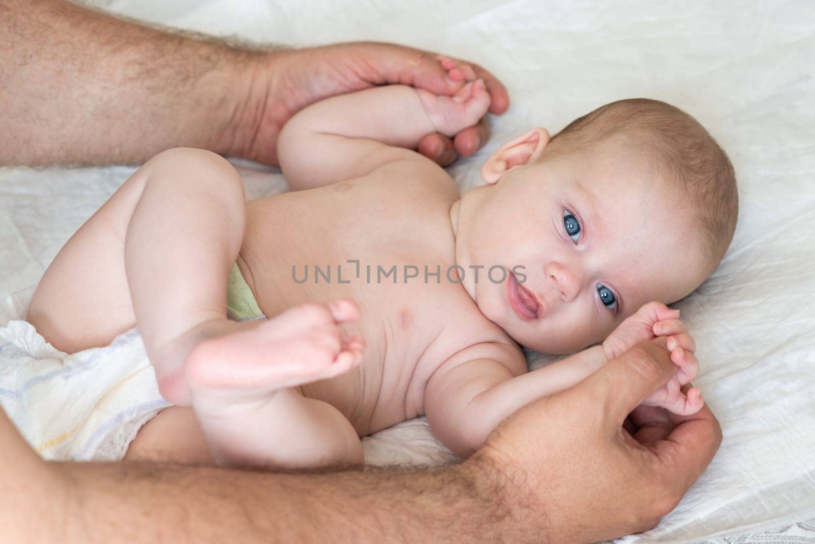 With skilled hands, a masseur delivers a therapeutic massage to a restful infant