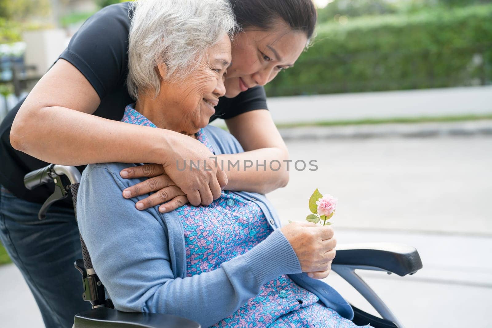 Caregiver help and care Asian senior woman patient sitting on wheelchair, healthy strong medical concept. by pamai