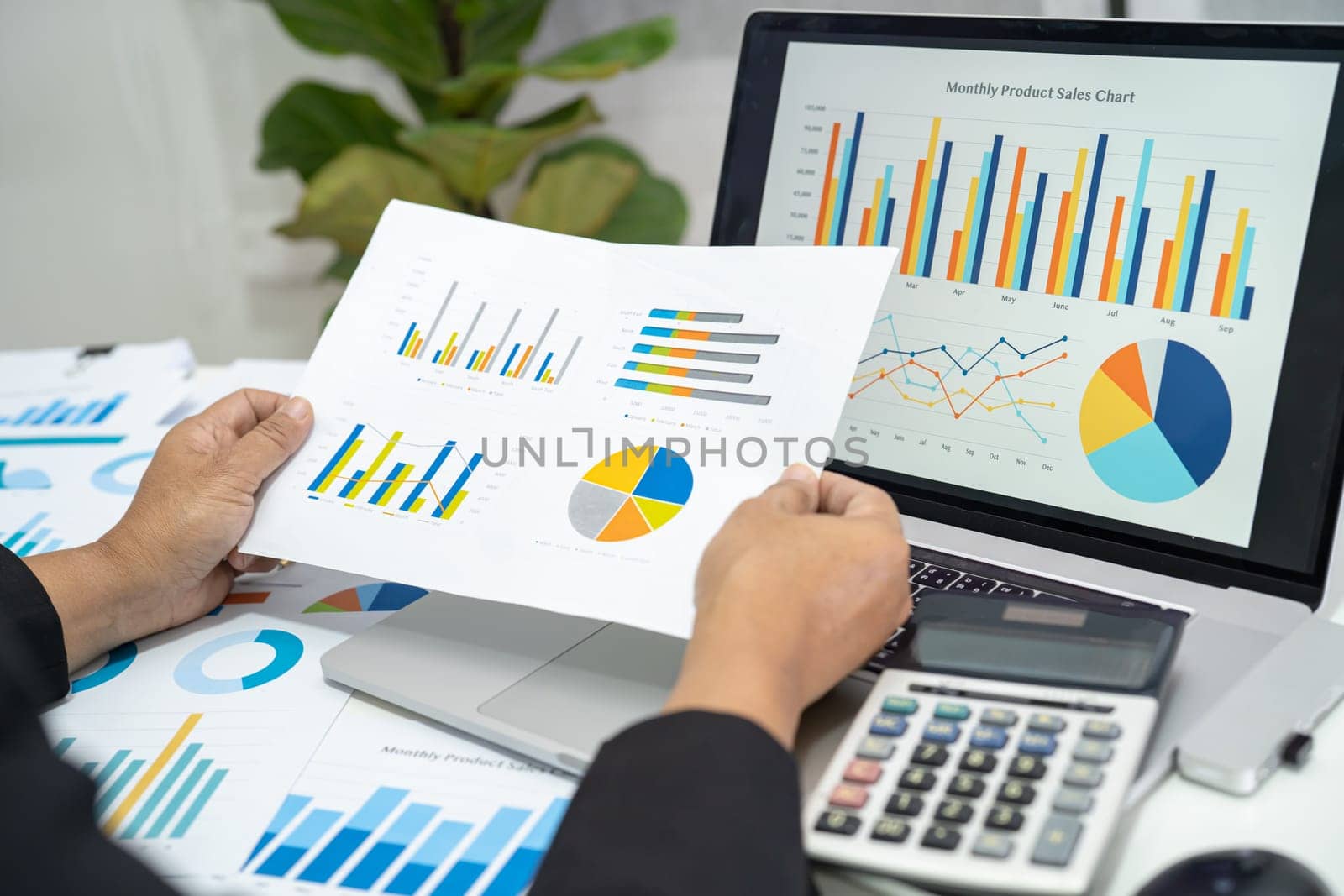 Asian accountant working and analyzing financial reports project accounting with chart graph in modern office, finance and business concept. by pamai