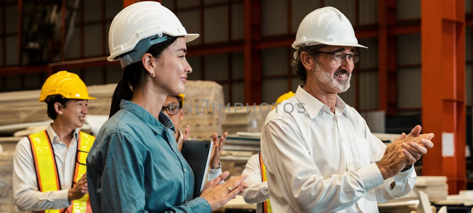 Happiness and joyful atmosphere, smiling factory worker and engineer celebrate with factory executive or manager after achieve factory output and surpassing the maximum quota. Exemplifying