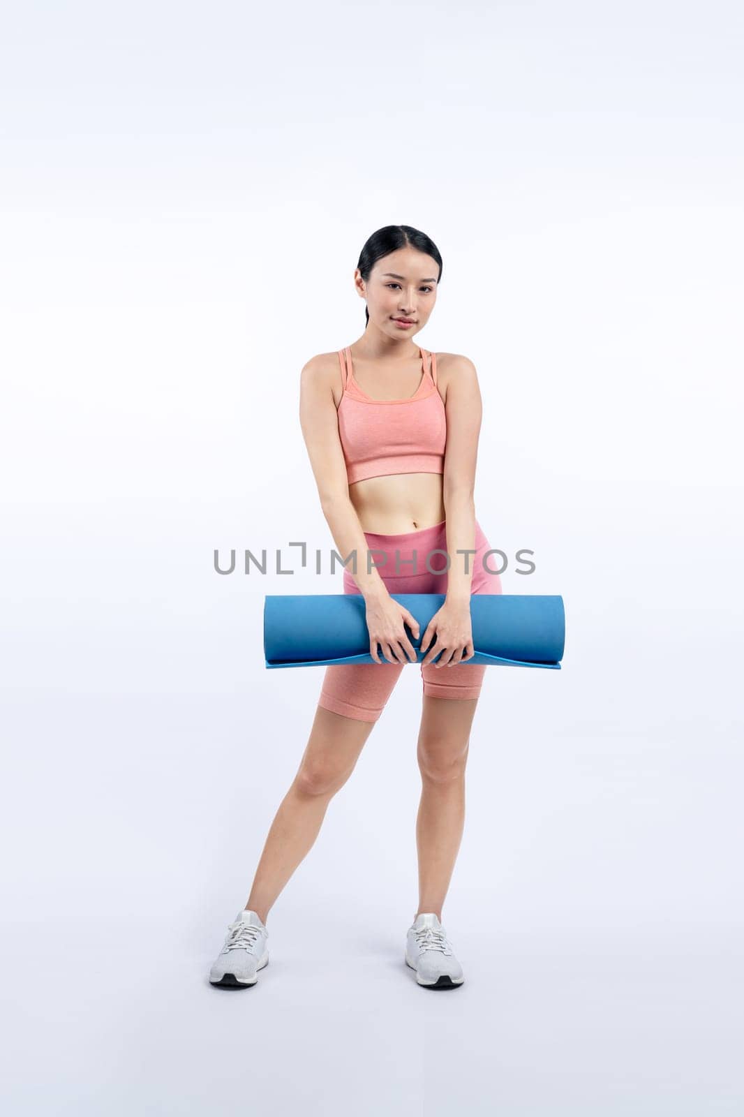 Young attractive asian woman portrait in sportswear with exercising mat. Healthy exercise and workout routine lifestyle concept. Studio shot isolated background. Vigorous