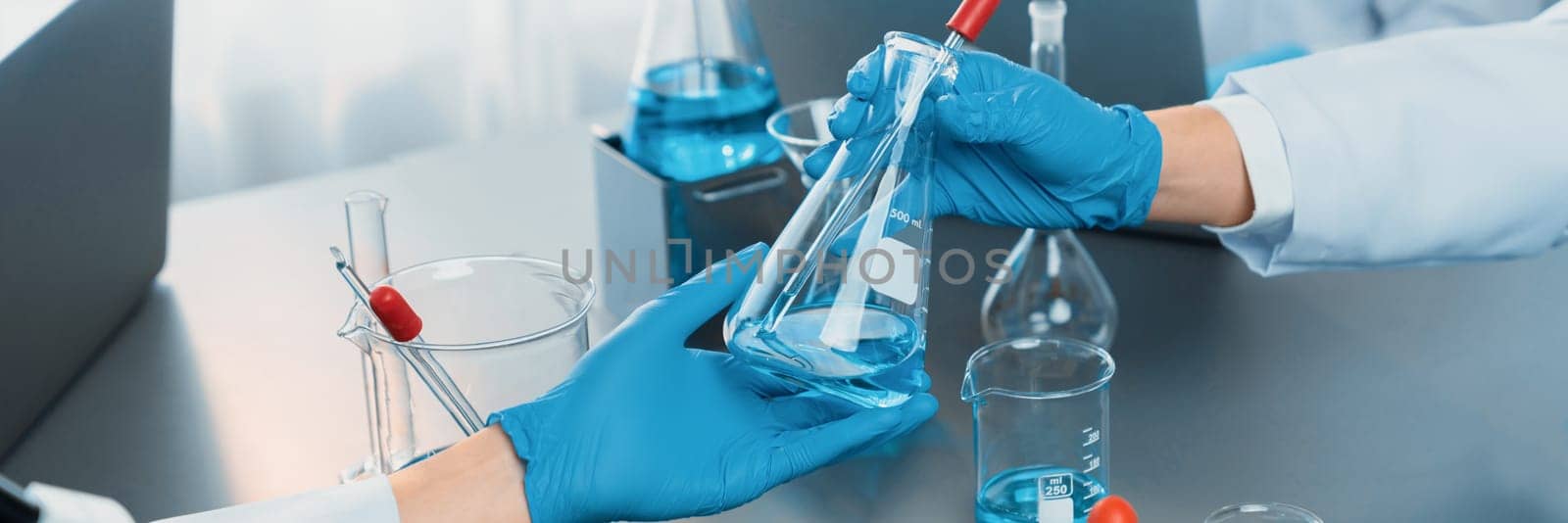 Group of dedicated scientist conduct chemical experiments and research in medical lab as groundbreaking developing for vaccine drug or antibiotic. Pharmaceutical and biochemistry laboratory. Neoteric