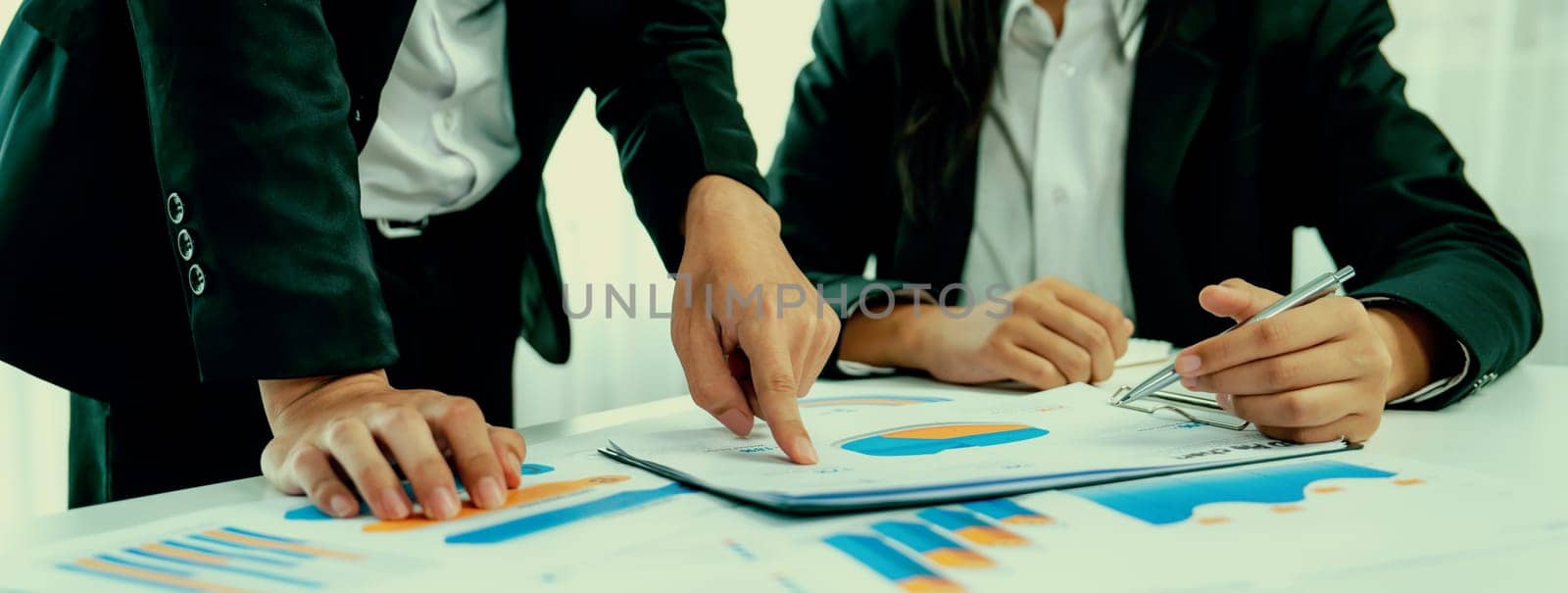 Business people in group meeting in formal attire share idea discussing report for company profit in creative workspace for start up business shot in close up view on group meeting table . Oratory .