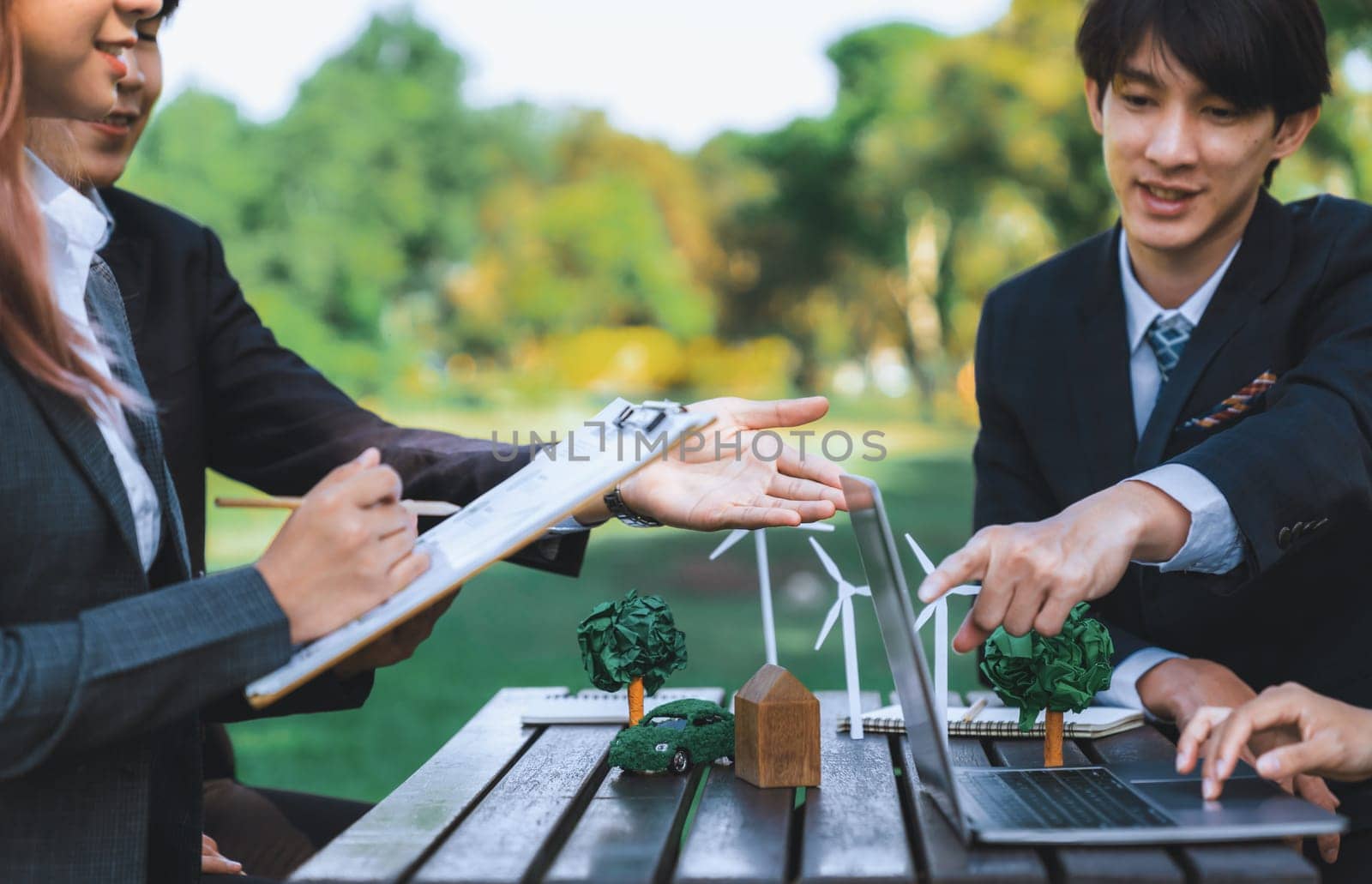 Group of asian business people presenting environmentally friendly development plan and sustainable technology project for greener future, establishing outdoor eco business office at natural park.Gyre