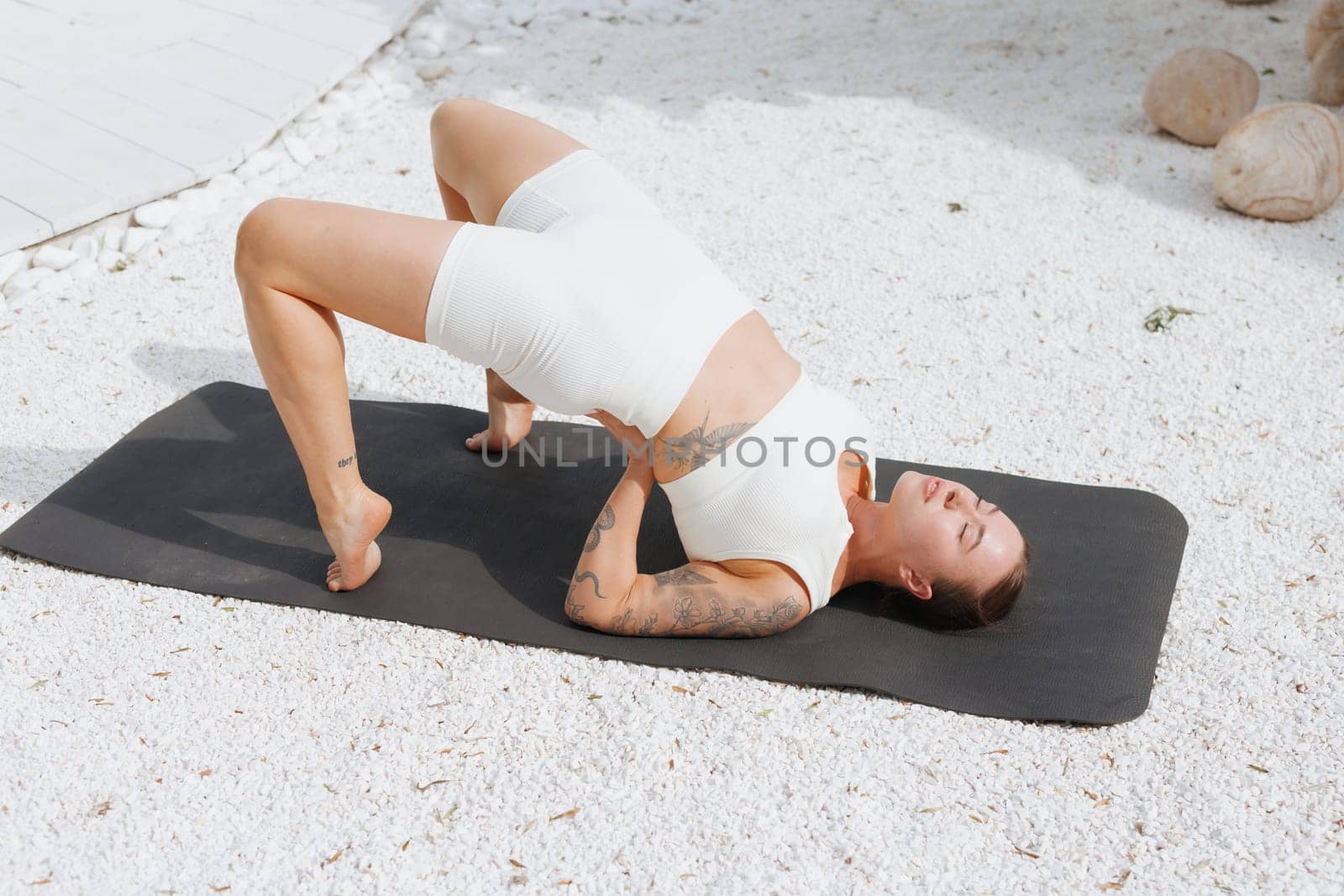 yoga stretching outdoors. side view of overweight woman practicing yoga on white background, body care concept, outdoor workout