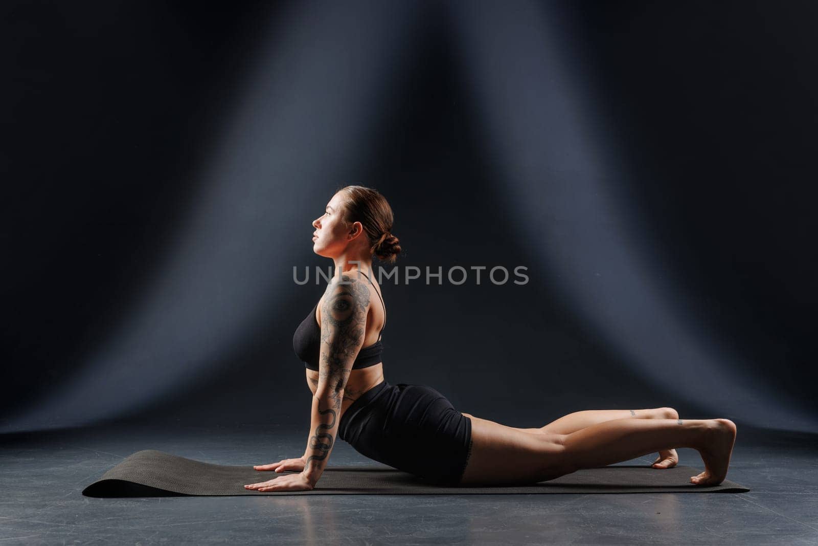 girl doing yoga and stretching, yoga and stretching poses on a dark background, yoga practice, body stretching concept
