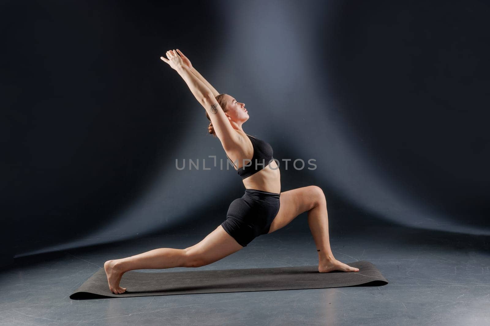 girl doing yoga and stretching, yoga and stretching poses on a dark background, yoga practice, body stretching concept