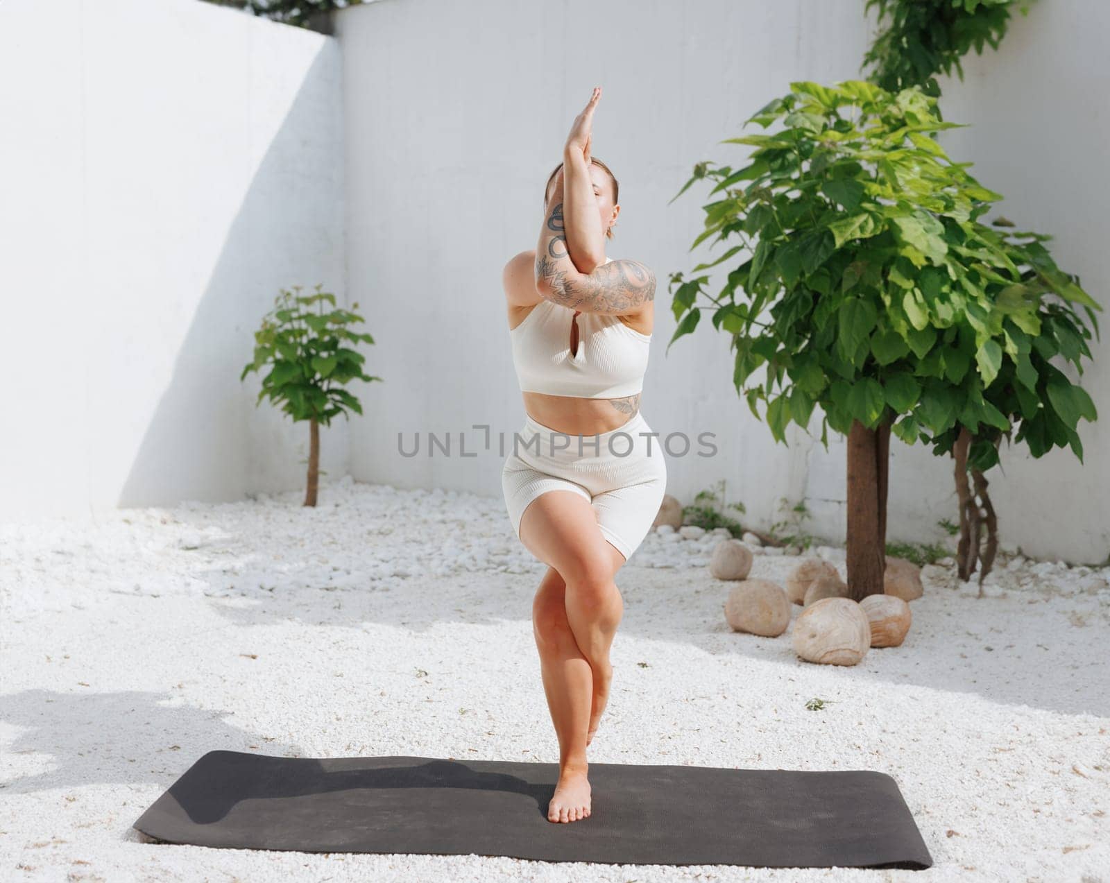 yoga stretching outdoors. side view of overweight woman practicing yoga on white background, body care concept, outdoor workout