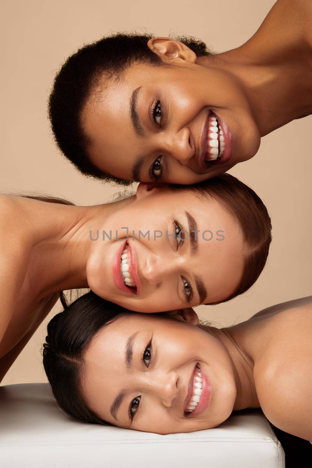 Three Multicultural Ladies Posing Smiling To Camera Over Gray Background. Multiethnic Female Beauty Portrait, Vertical