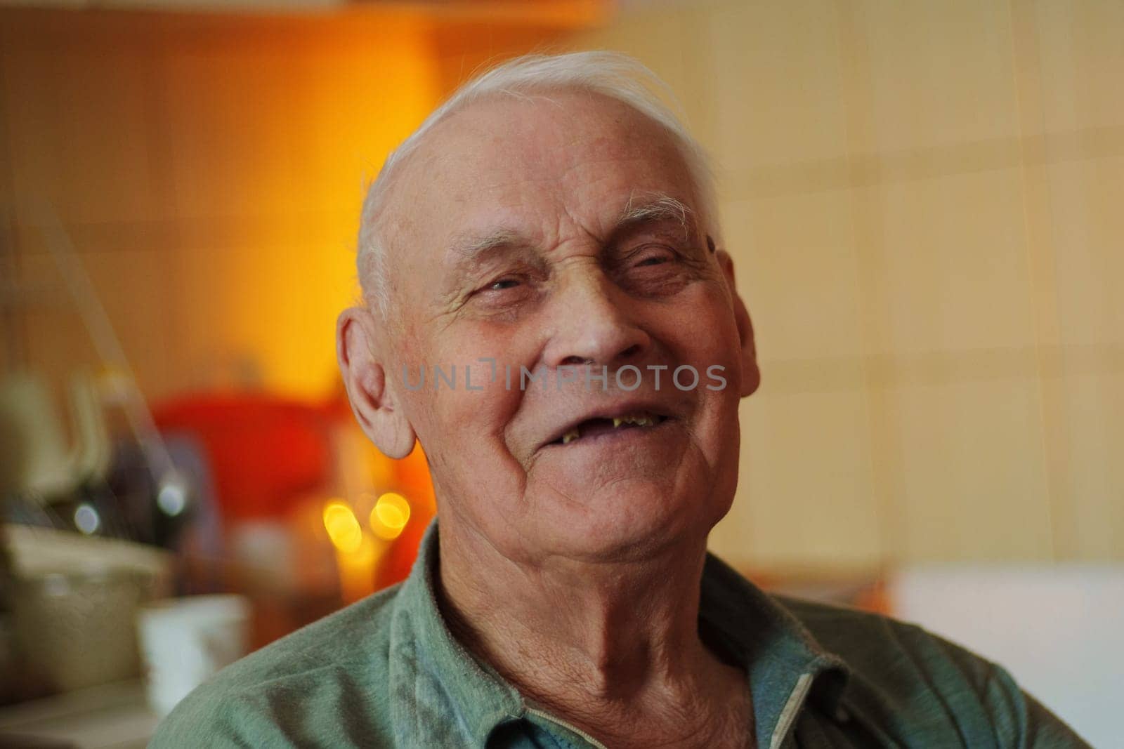 An elderly man sits contentedly in a kitchen, basking in the soft light of the late afternoon. His peaceful expression reflects a sense of warmth and happiness