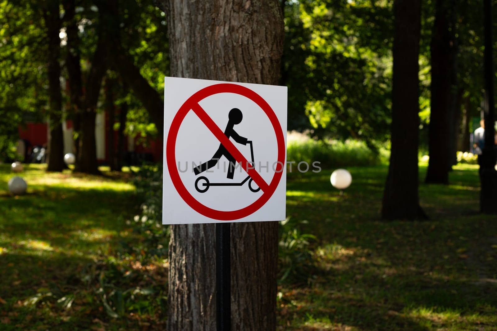 Scooter symbol in park prohibiting riding on public street in city. Illegal movement on an electric scooter