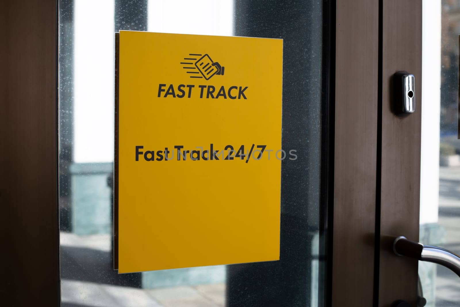 Fast Track 24 hours sign on building door. Designation of place for quick check in for trains and planes. Sign at entrance of building for quick route