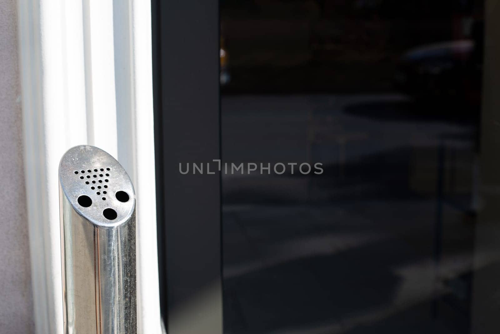 Outdoor ashtray for cigarettes, pole with hole for throwing away cigarette butts in smoking area, modern problem of people smoking and unhealthy lifestyle