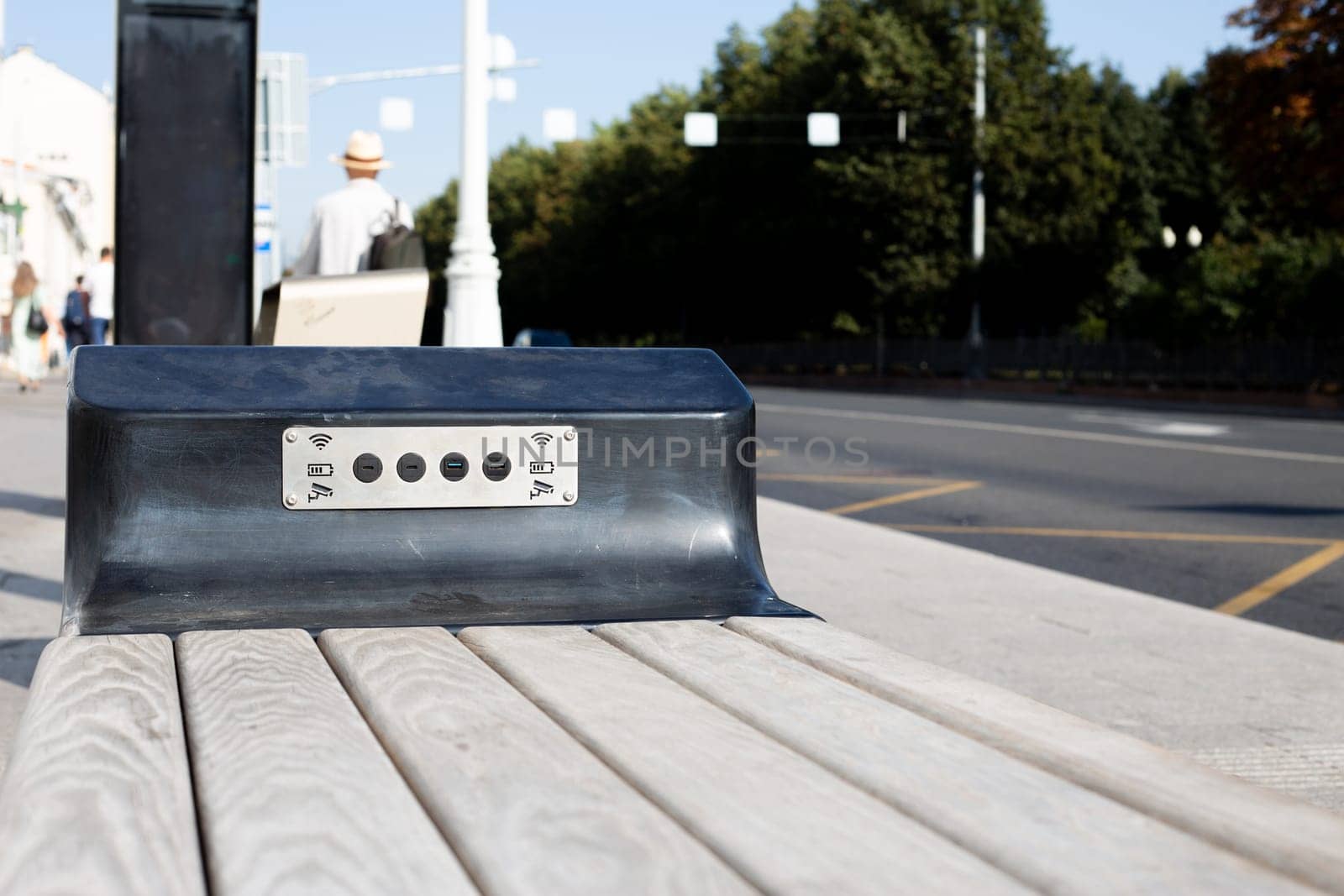 Modern bench with Wi-Fi and USB connectors for charging phone at public transport stop in city, accessible environment in town