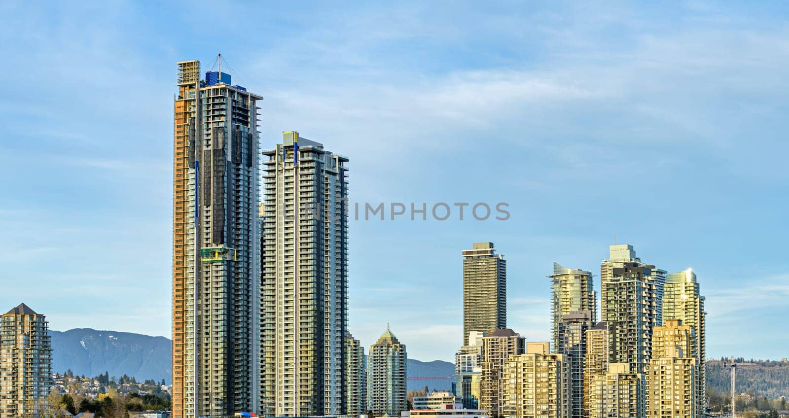 Settled and new high rise residential buildings of Brentwood district on blue sky background