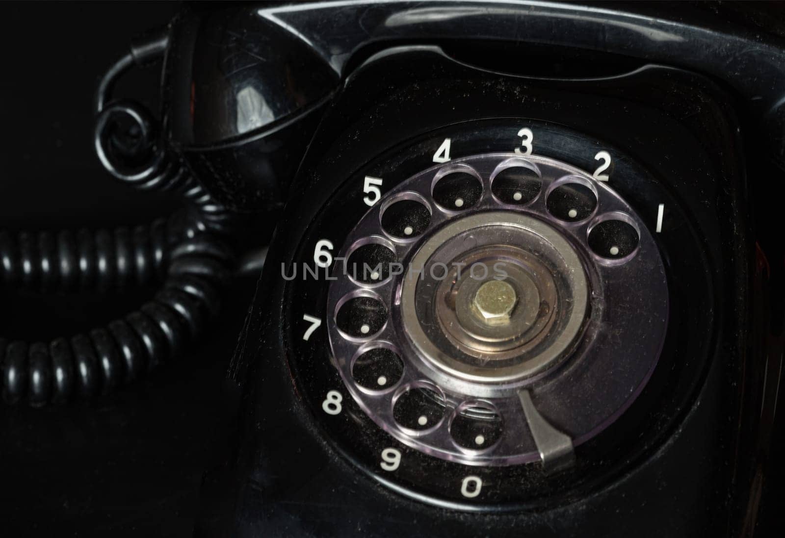 Bangkok, Thailand - 17 Sep, 2024 - Old black retro rotary telephone on black background. Vintage style, Light and Shadow, Space for text, Selective focus.