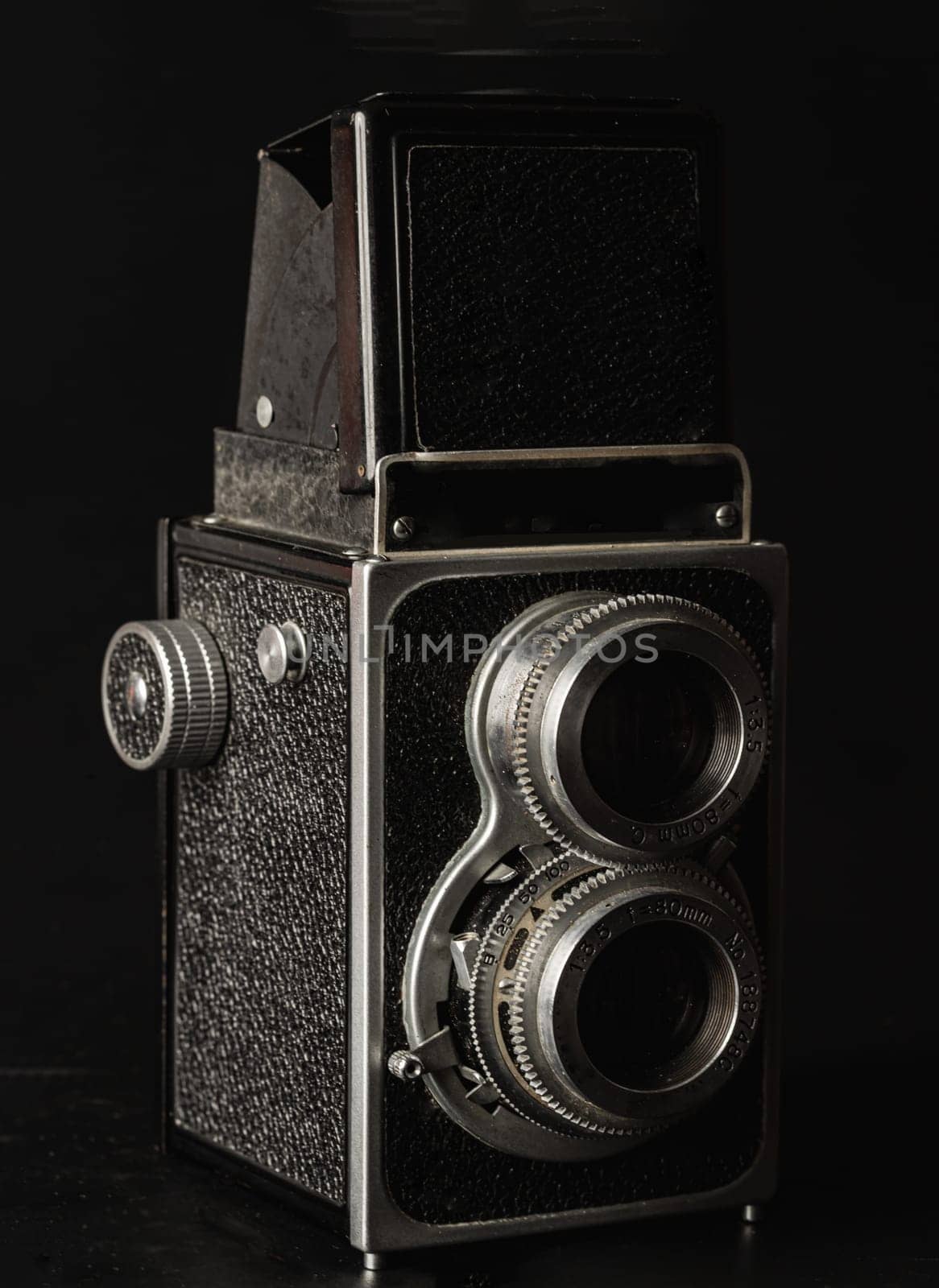 Bangkok, Thailand - 17 Sep, 2024 - Vintage twin lens reflex photo camera or Old two lens medium format film camera on black background. An idea of old camera and memory, Light and Shadow, Space for text, Selective focus.