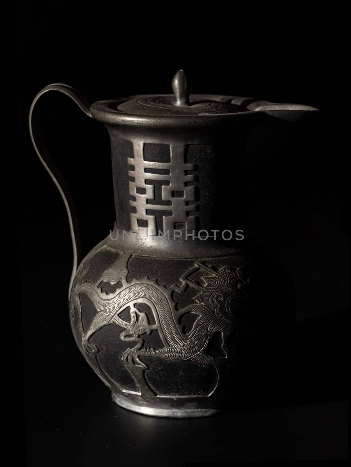 Bangkok, Thailand - 18 Sep, 2024 - Chinese traditional teapot with dragon pattern and chinese characther double (Translation meaning is Double Happiness). Antique metal teapot usually it use For Chinese tea ceremony during wedding day. Light and Shadow, Space for text, Selective focus.