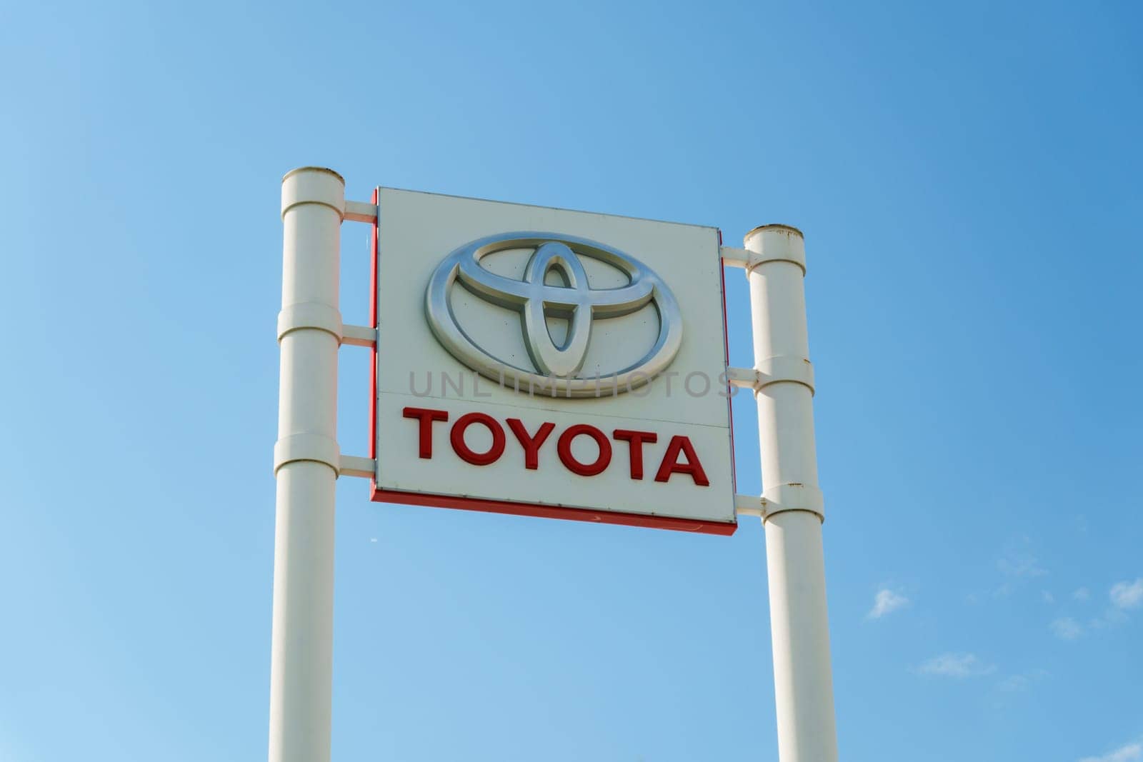 Tyumen, Russia-August 10, 2024: Toyota dealership sign under a clear blue sky with visible greenery in the foreground