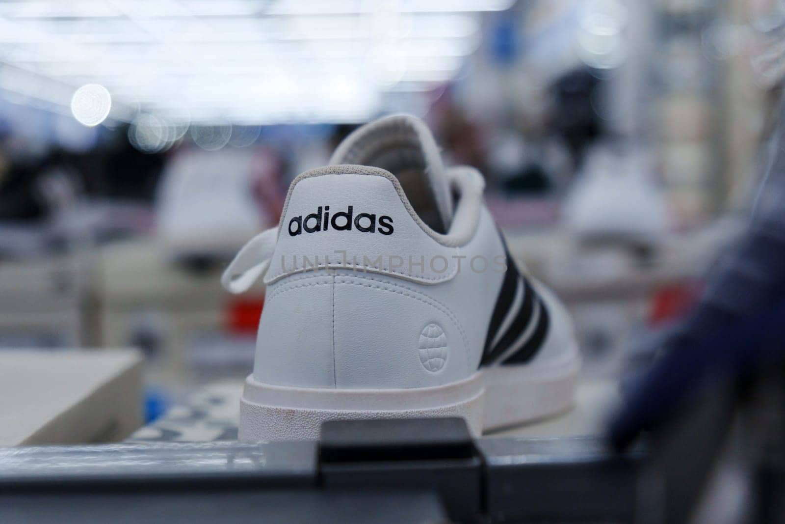 Tyumen, Russia-August 11, 2024: White athletic shoes adidas displayed on shelves in a retail store during the day