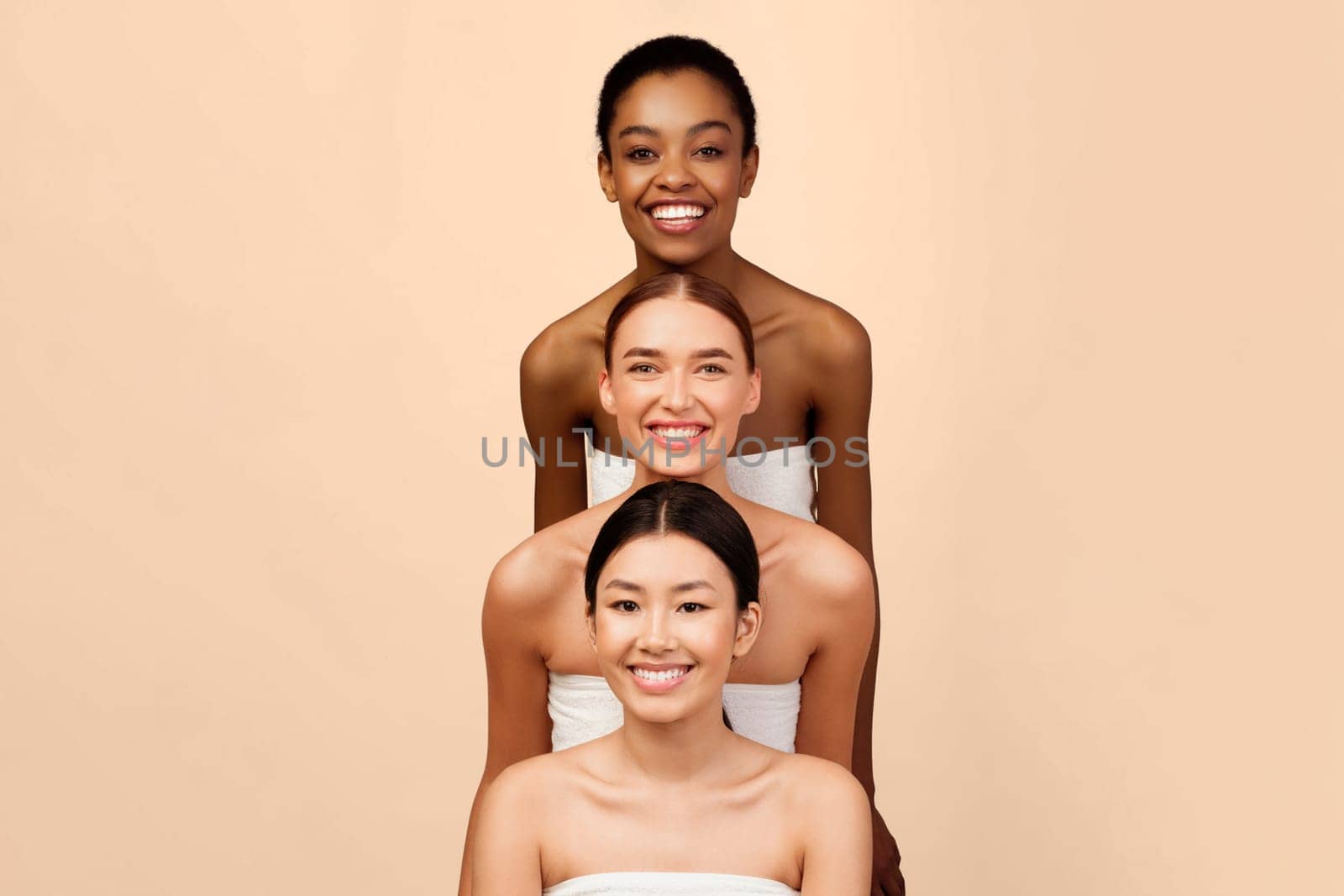 Group Of Three Diverse Women Standing And Posing Smiling At Camera Over White Studio Background. Vertical Beauty Portrait