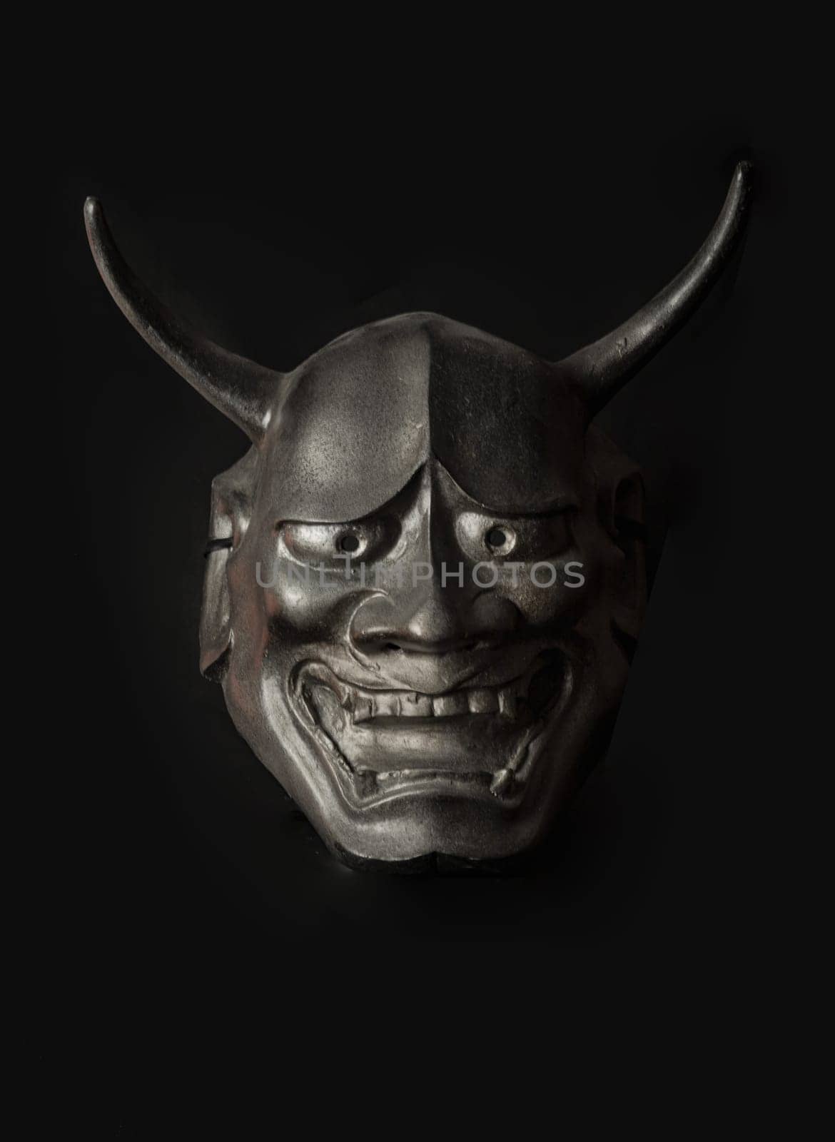 Bangkok, Thailand - 19 Sep, 2024 - Traditional japanese mask of a demon on black background. The mask shadow kabuki is a classical japanese dance drama with theater form, Light and Shadow, Space for text. Selective Focus.