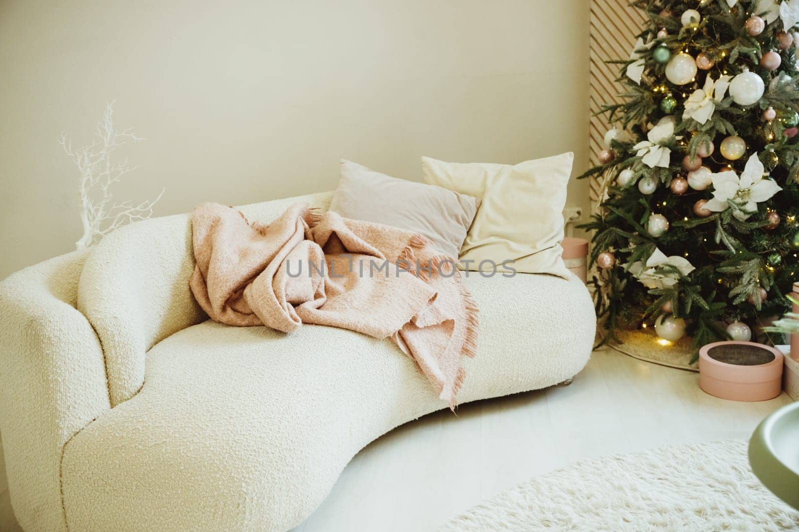 Calm image of interior luxury home living room decorated christmas tree and gifts, sofa covered with blanket.
