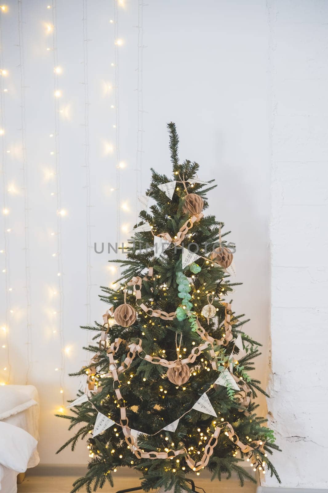 Fashionable eco-friendly Christmas tree toys made of paper, New Year's garland on a lamb wool fabric background.
