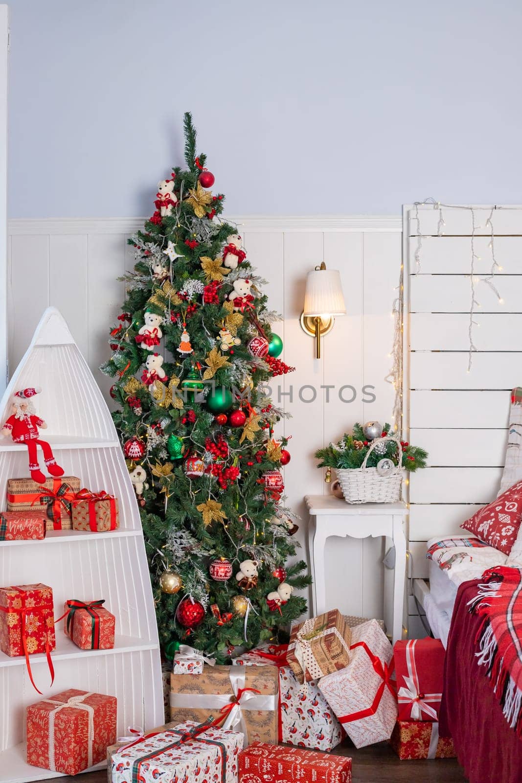 Interior of festive bedroom with comfortable bed and Christmas tree