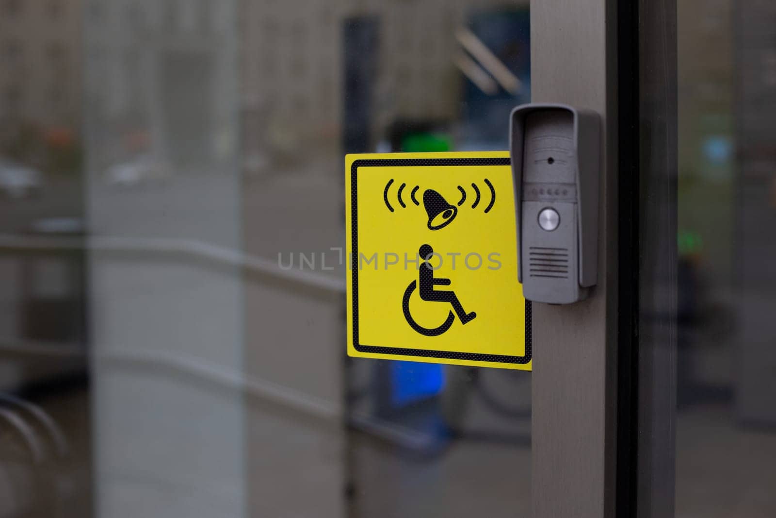 Button to call staff to assist person with disabilities at entrance. Accessible environment for people in wheelchair, entrance to modern building with conditions for the disabled people