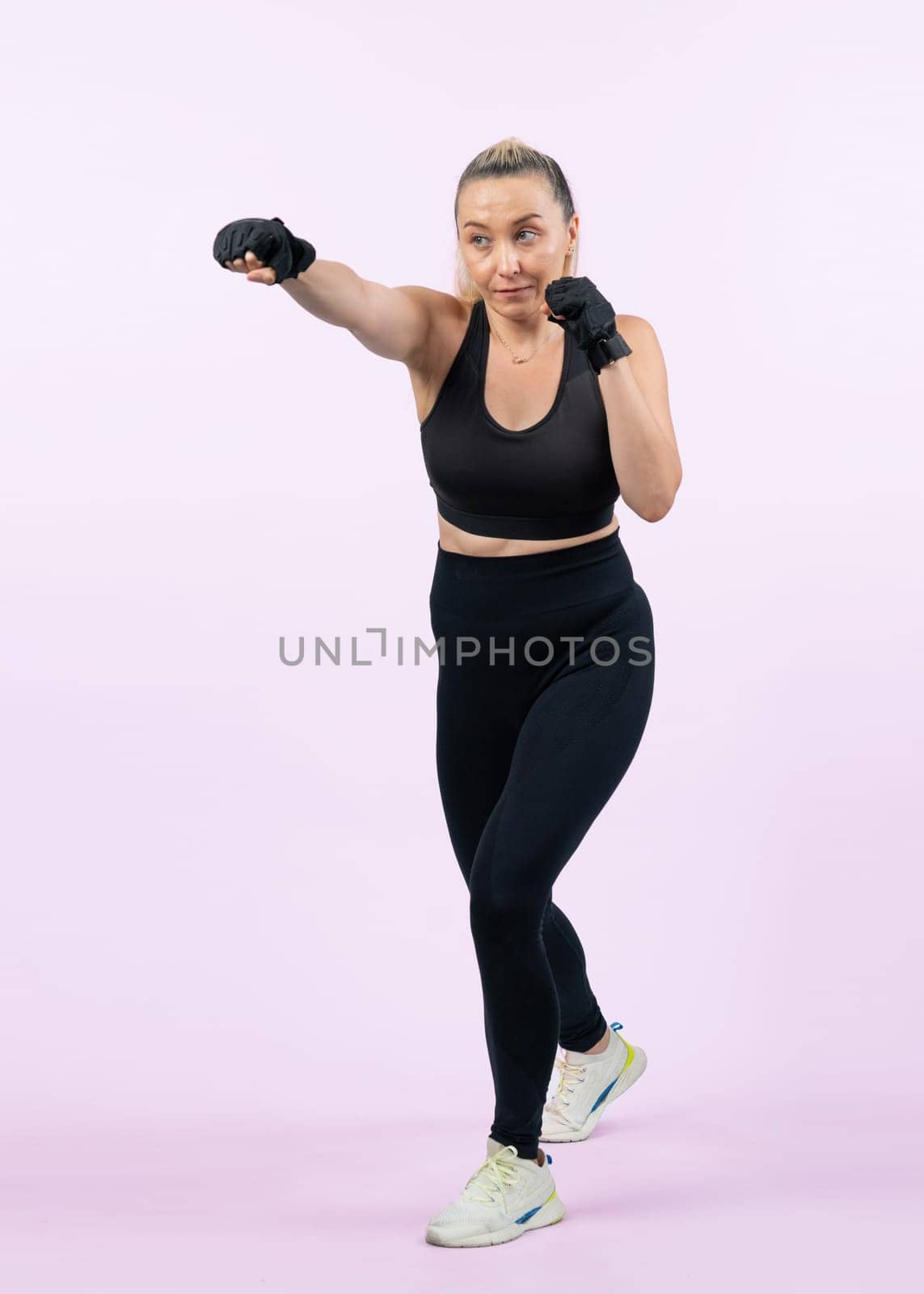 Full body length shot athletic and sporty senior woman doing boxing. Clout by biancoblue