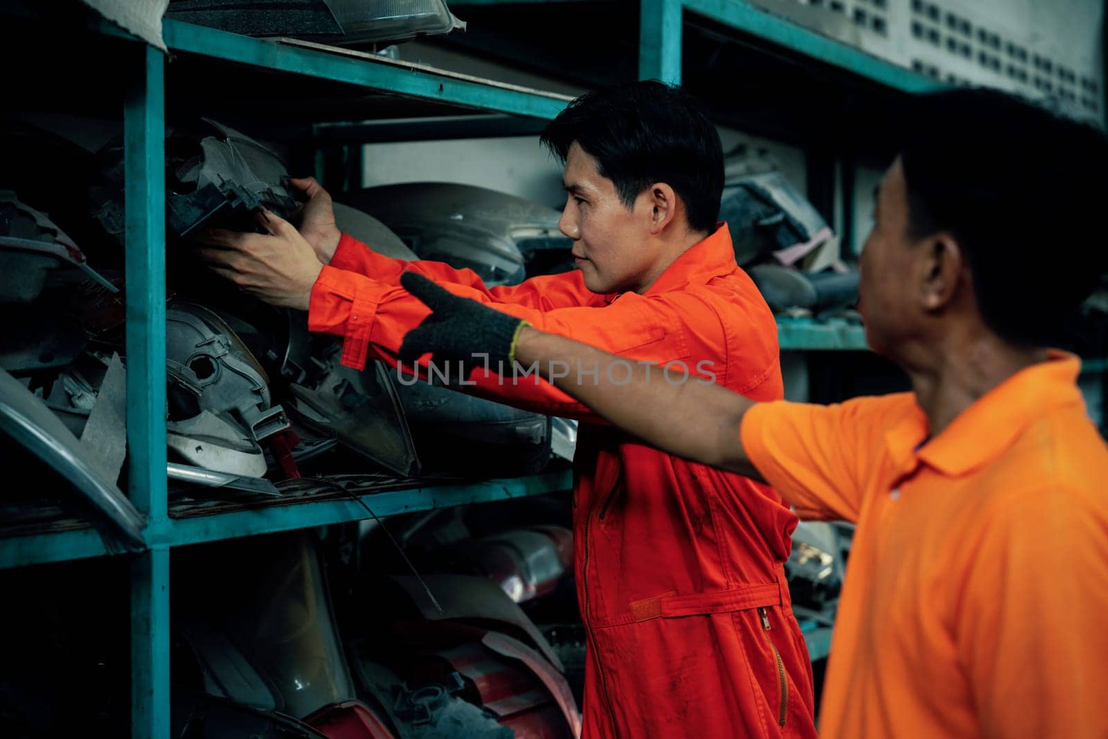 Mechanic worker inspect spare vehicle parts stored in inventory. Oxus by biancoblue