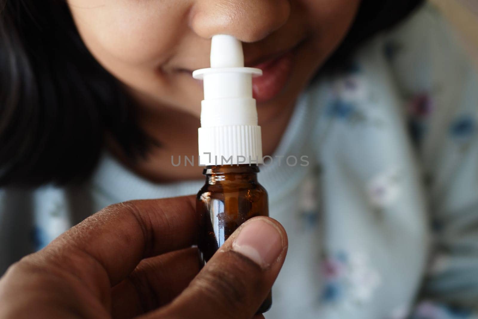 close up of sick child using nasal medicine spray by towfiq007