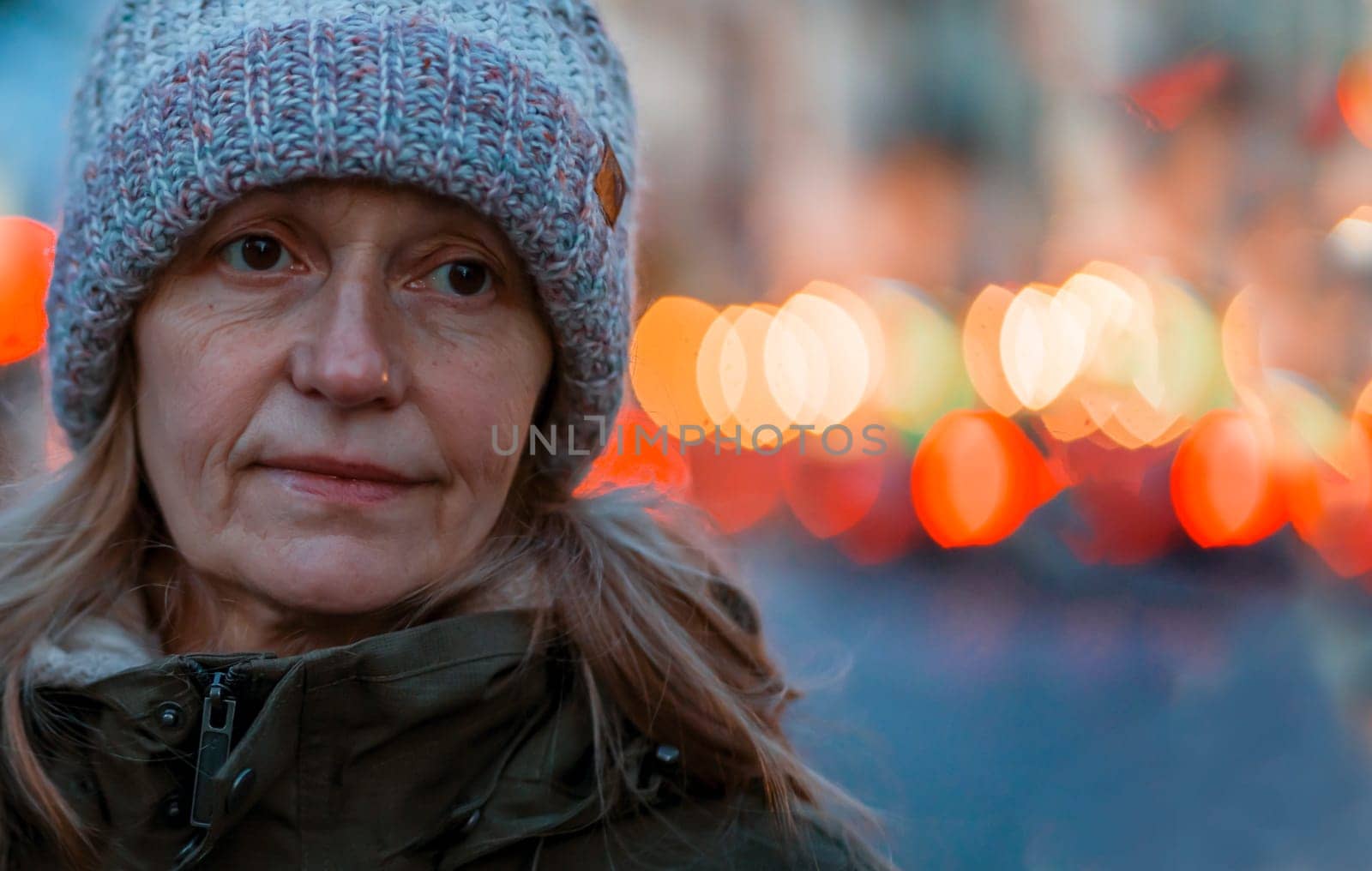 An elderly 60 beautiful woman with a kind smile is walking outdoors on a sunny autumn day, a happy old lady, a grandmother takes care of her appearance, natural beauty with wrinkles portrait closeup.