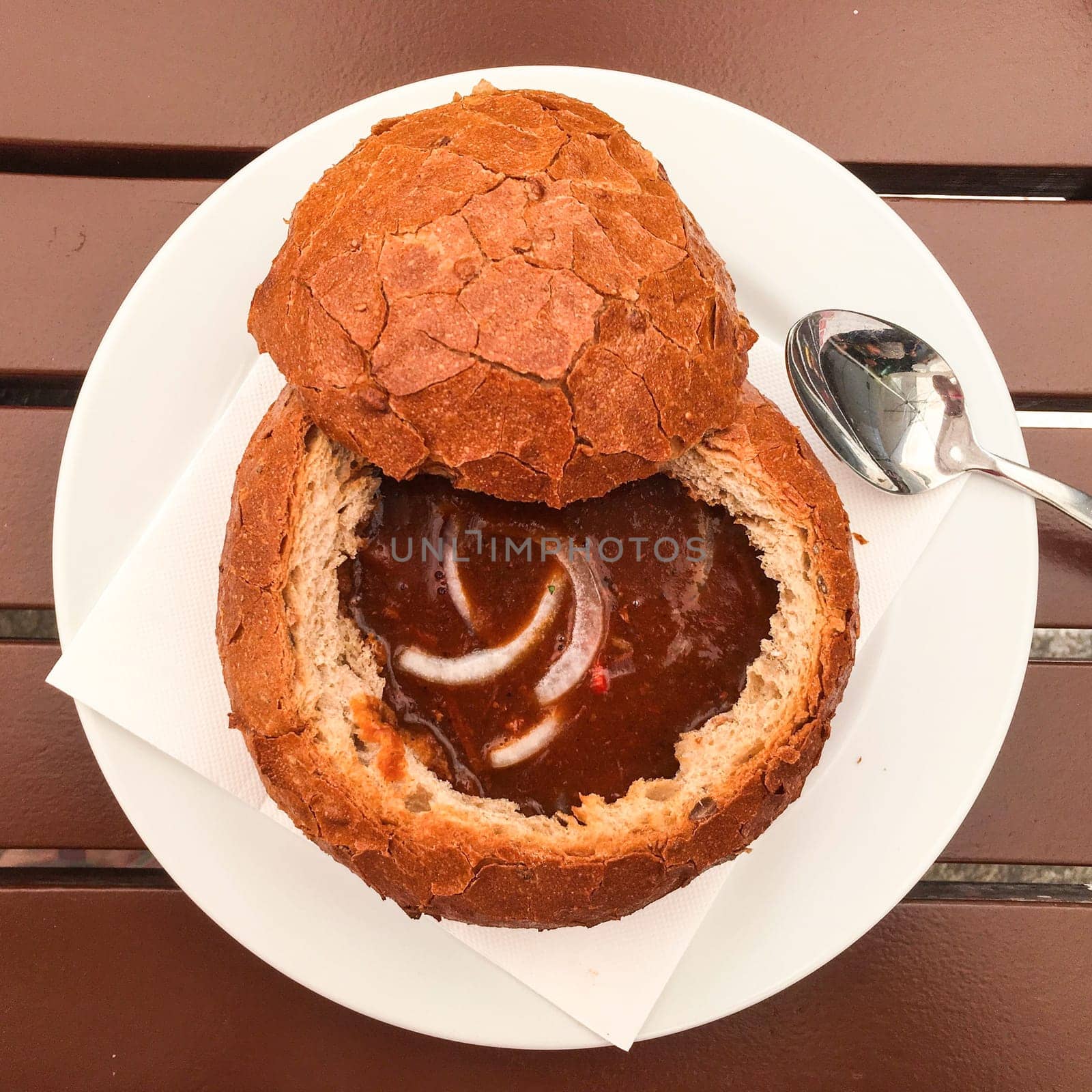 Goulash or thick soup is served in bread top view. Czech traditional cuisine