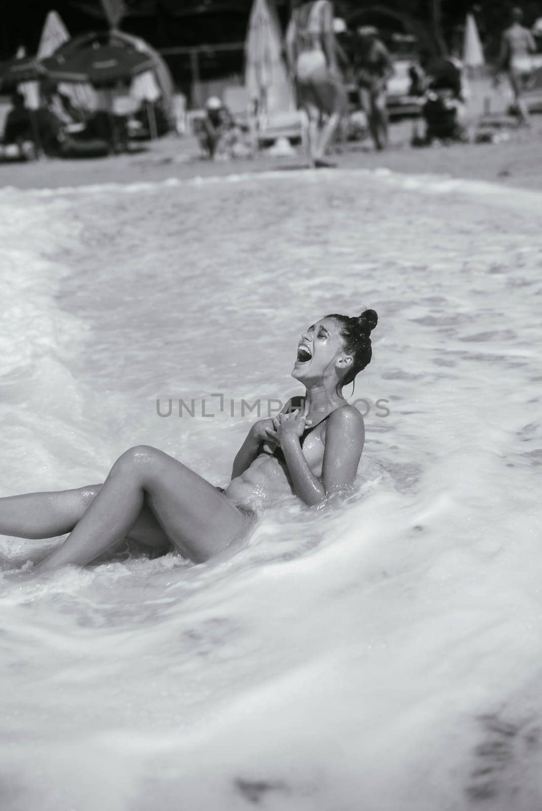 A carefree woman joyfully laughing and splashing in the warm ocean waves, capturing the true essence of summer joy