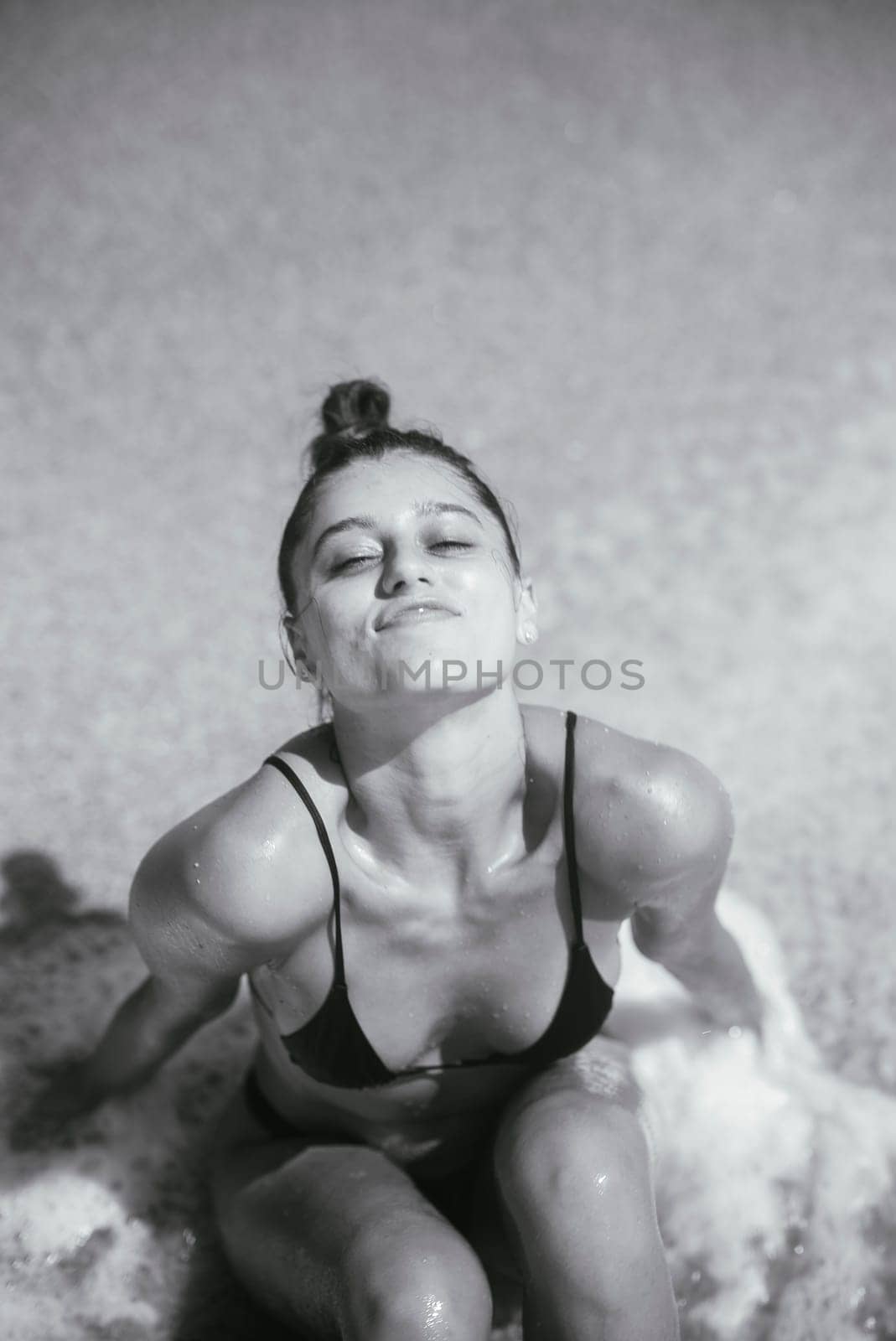 A stunning monochrome portrait of a woman by the shore, beautifully capturing raw beauty and confidence