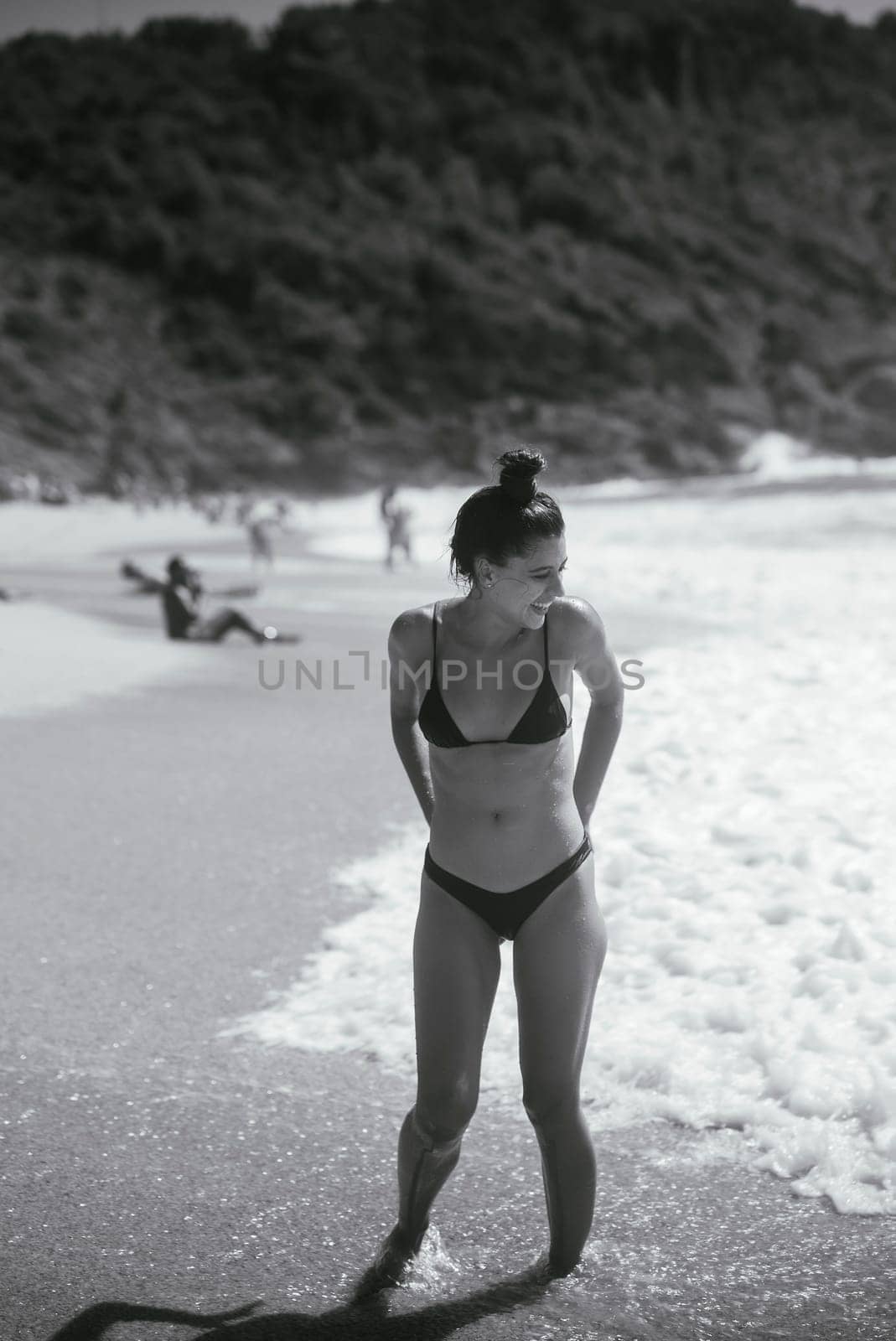 A stunning beach scene with a woman in a stylish bikini, embodying summer vibes and relaxation under the sun