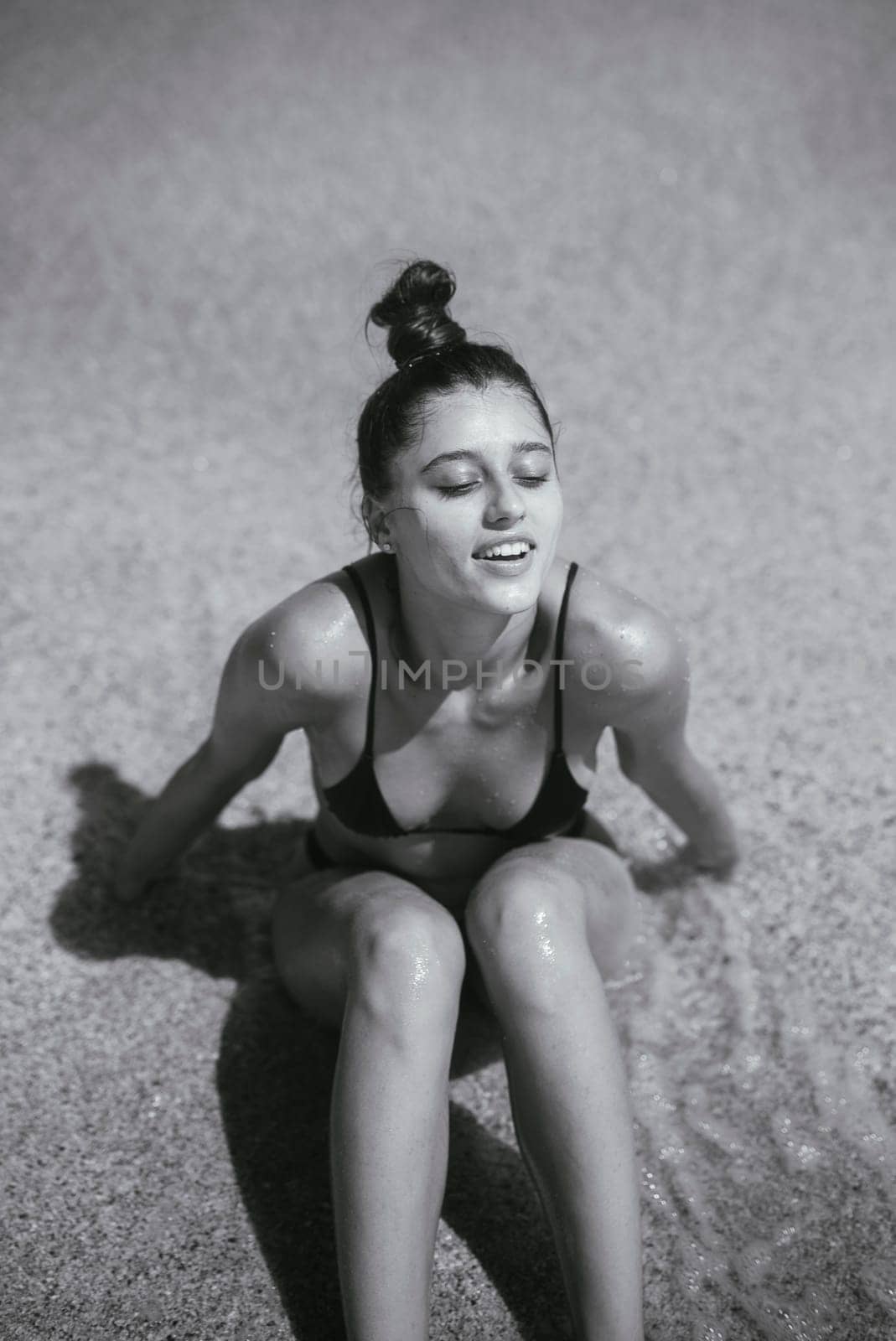 A serene moment captured in a black and white photo, showing a woman enjoying the peacefulness of the water