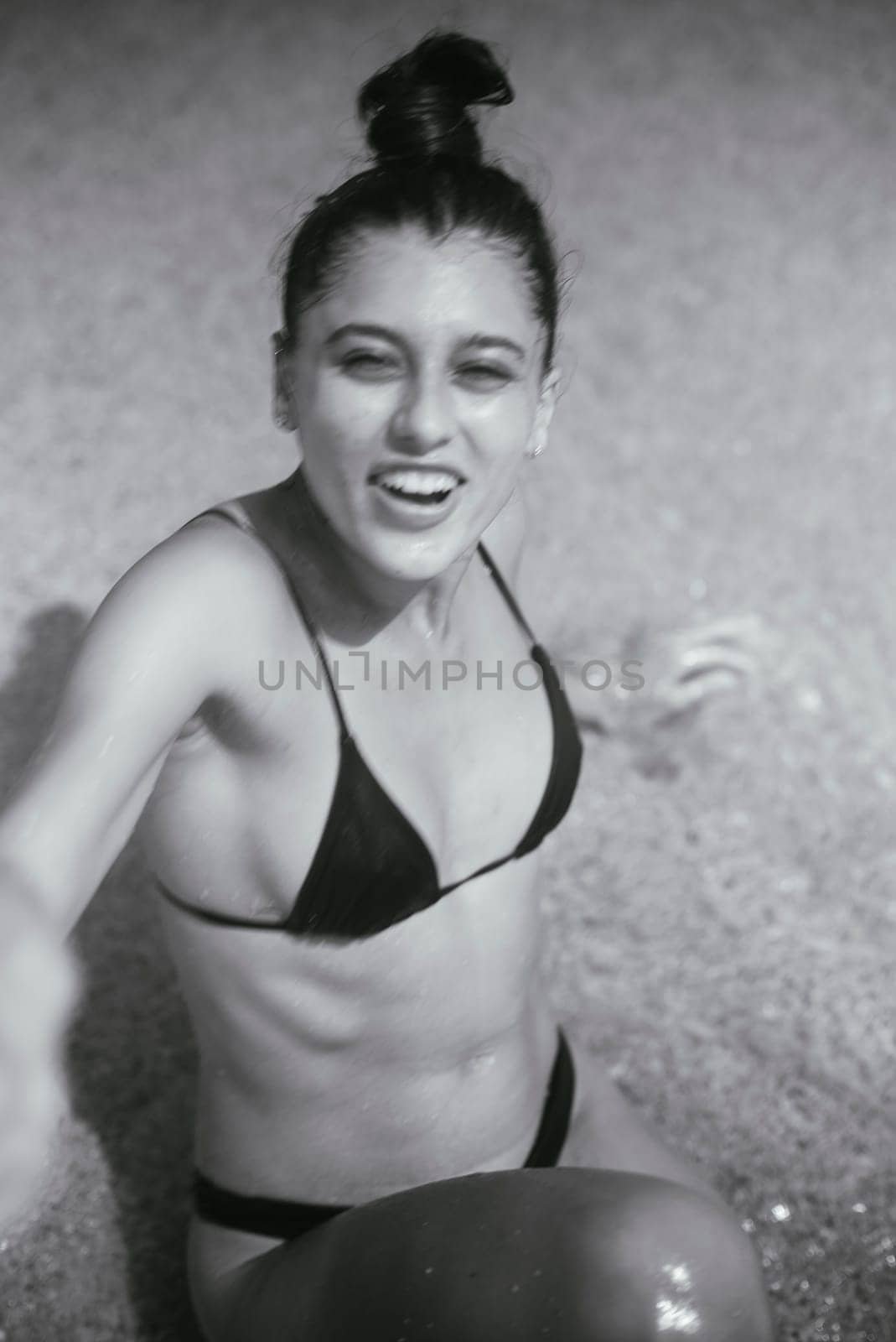 A young woman at the beach relishing a moment filled with joy, spontaneity, and beauty conveyed in black and white