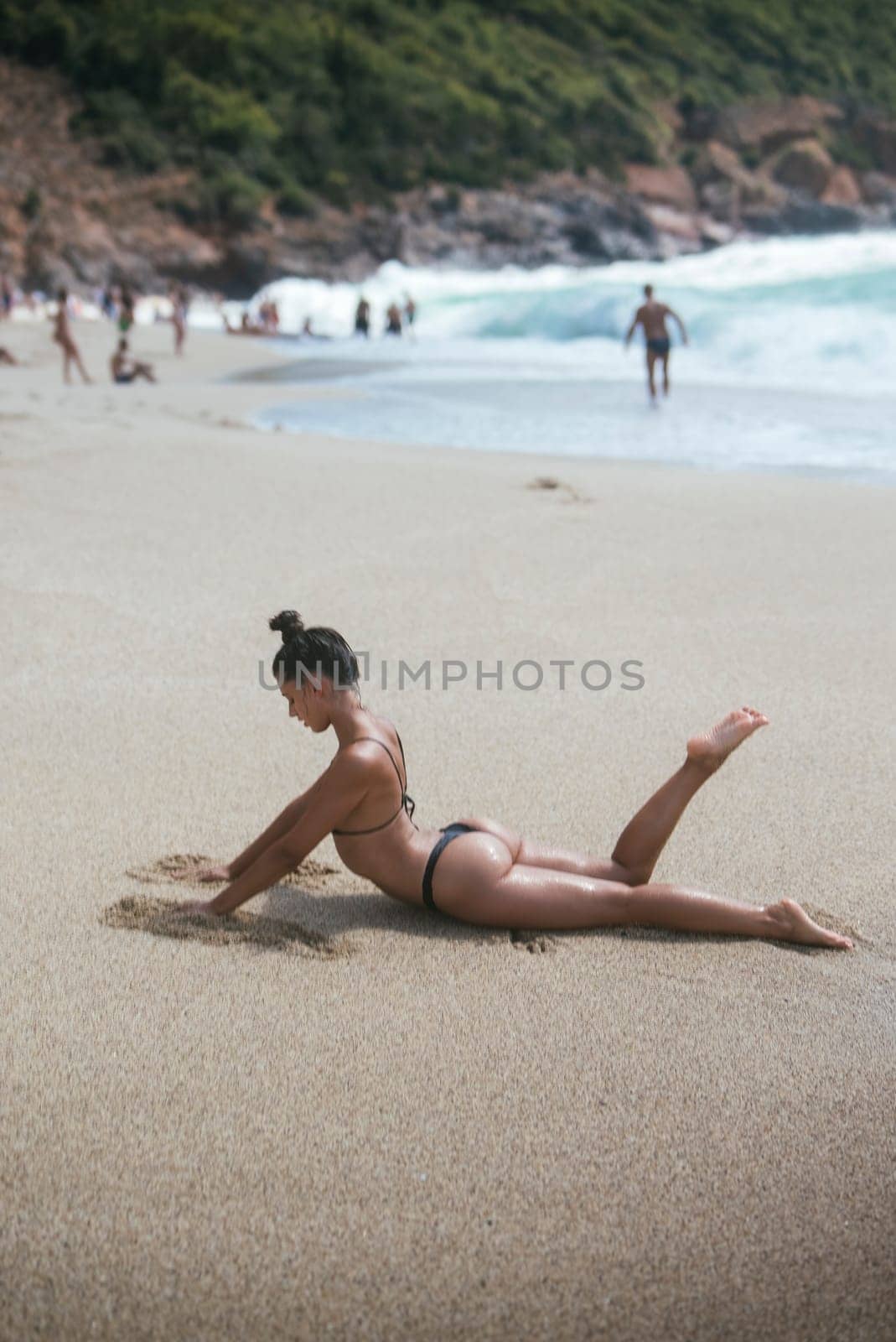 A tranquil beach scene showcasing sunbathing individuals and gentle ocean waves, perfect for summer vibes