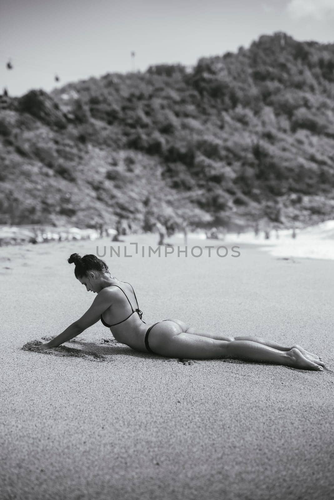 A beautiful and tranquil scene of a woman peacefully relaxing on a warm beach, fully embracing the sun and nature
