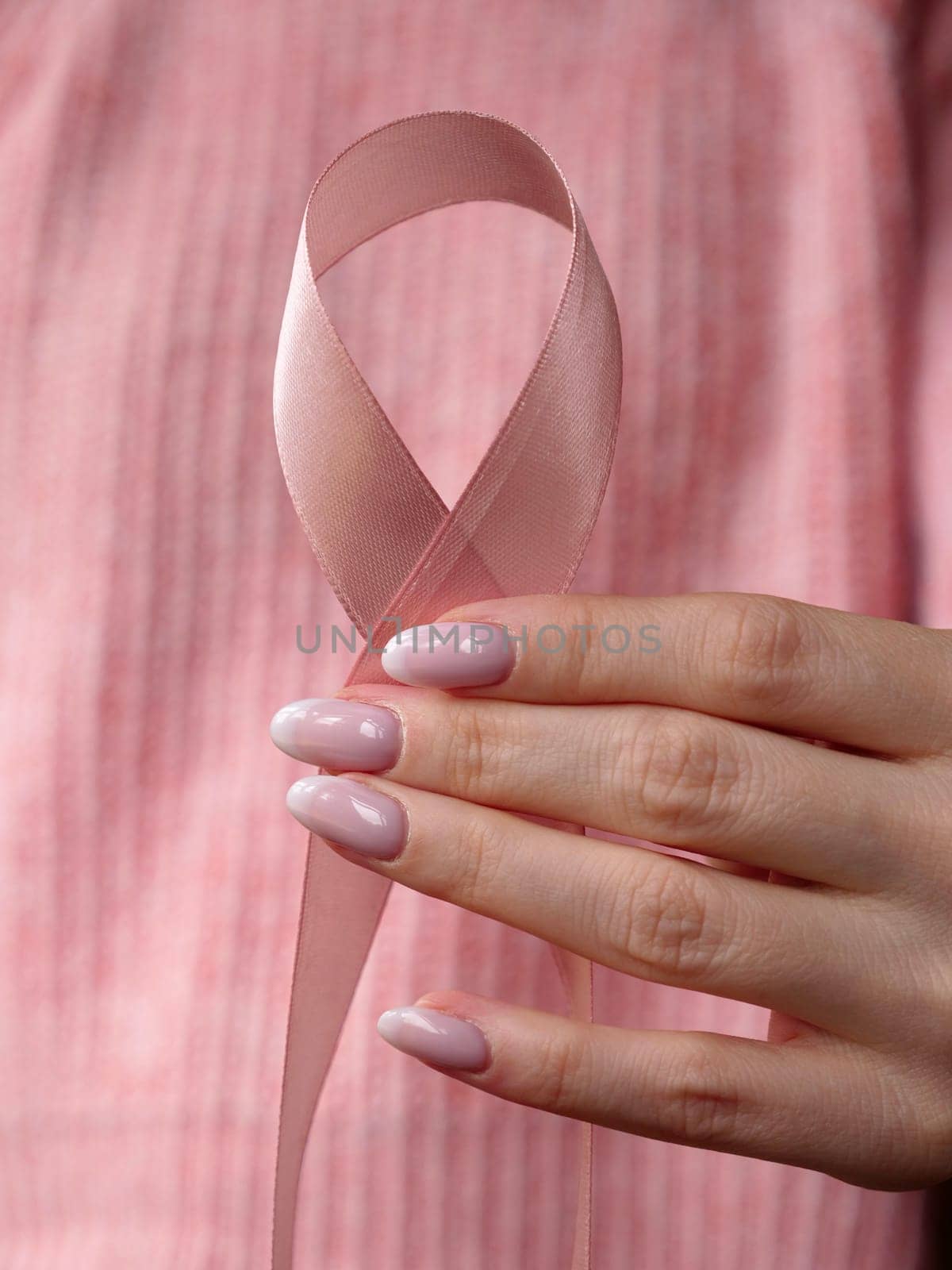 Pink October Breast Cancer Awareness month, woman hand with pink Ribbon in hospital for support people life and illness. Vertical