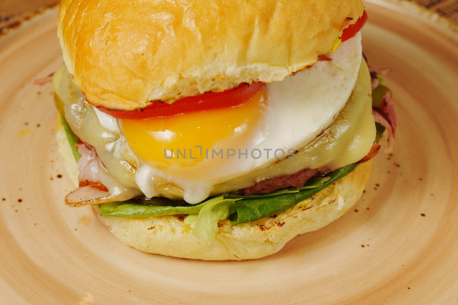 delicious breakfast burger topped with an egg, fresh vegetables, and melted cheese on a warm bun ready
