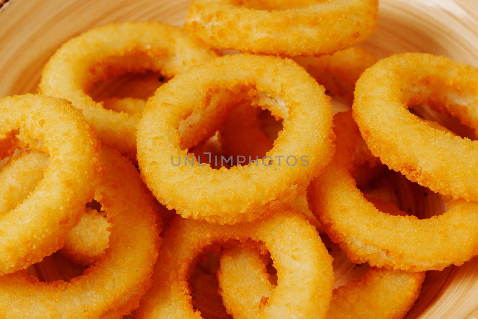 Crisp, golden onion rings lay in a rustic basket, their crunchy texture promising a flavorful bite