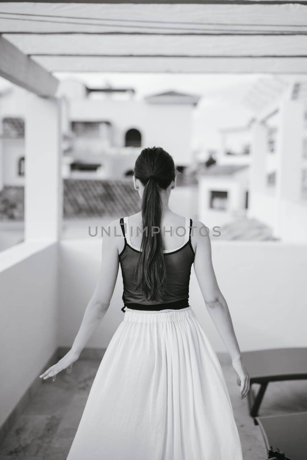 A graceful woman dressed in a flowing skirt is beautifully captured within a serene and calming monochrome setting