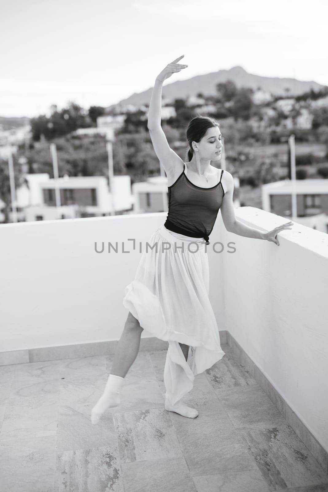A ballet dancer gracefully and elegantly performing on a picturesque terrace, captured beautifully in black and white