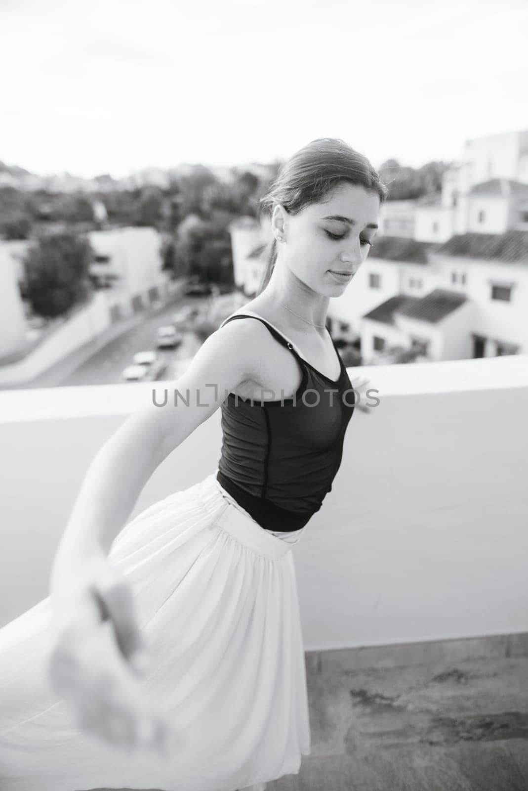 A stunning black and white photo shows a dancer gracefully balancing on a rooftop, showcasing artistry and poise