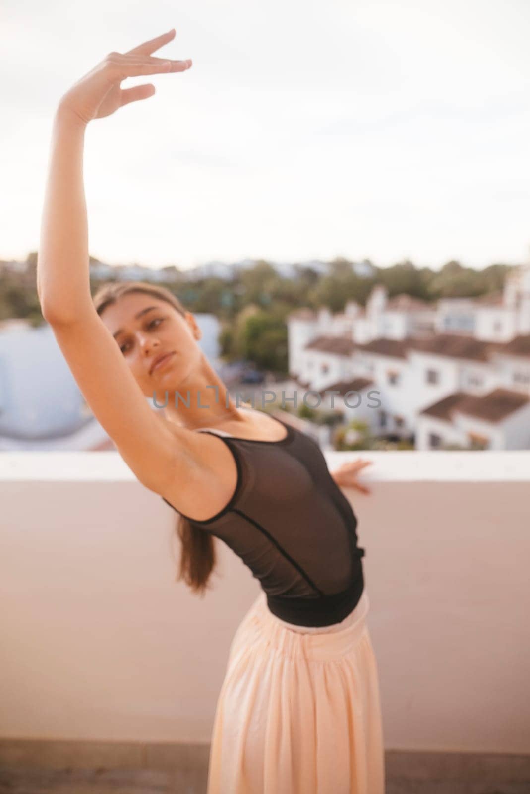 A graceful ballet dancer strikes a stunning and captivating pose on a rooftop, beautifully embodying elegance and poise